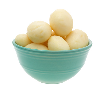 A small bowl filled with canned whole white potatoes isolated on a white background.
