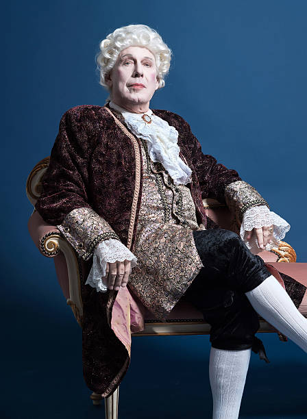 istock Retro baroque man with white wig sitting on antique couch. 498764331