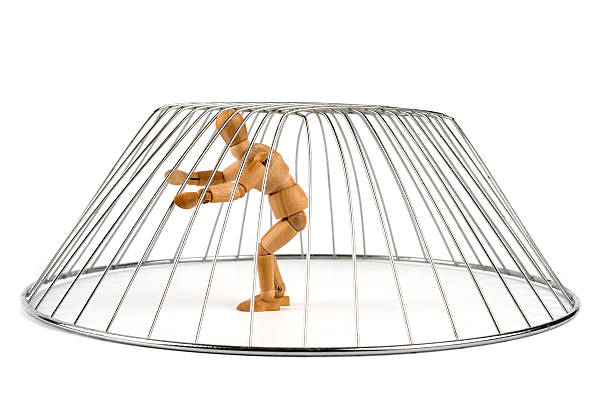 istock Wooden Mannequin isolated and trapped in a cage 498764413