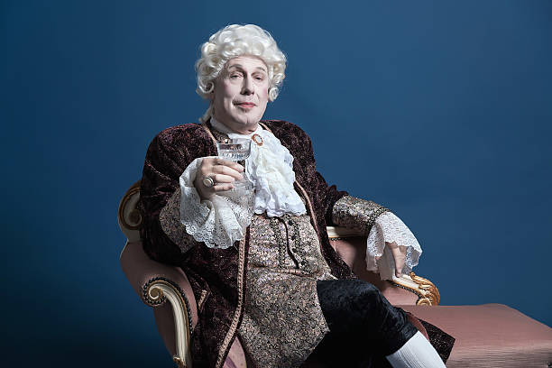 istock Retro baroque man with white wig holding a wine glass. 498765287