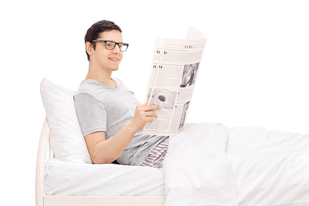 uomo funerale di letto e leggendo un quotidiano - mattress newspaper reading bed foto e immagini stock