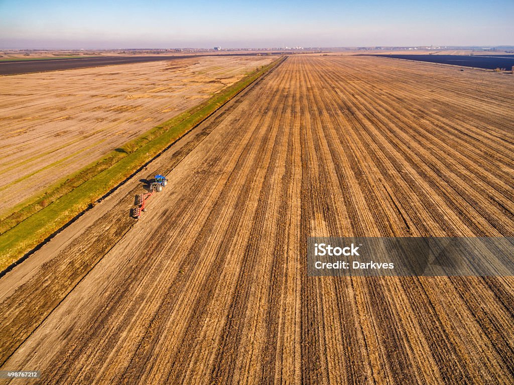 Tractor plowing the field Aerial view of tractor ploughing the field 2015 Stock Photo