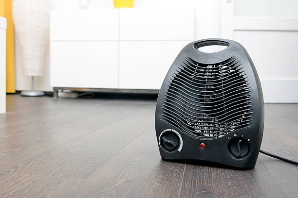 electric heater on laminate floor in the room stock photo