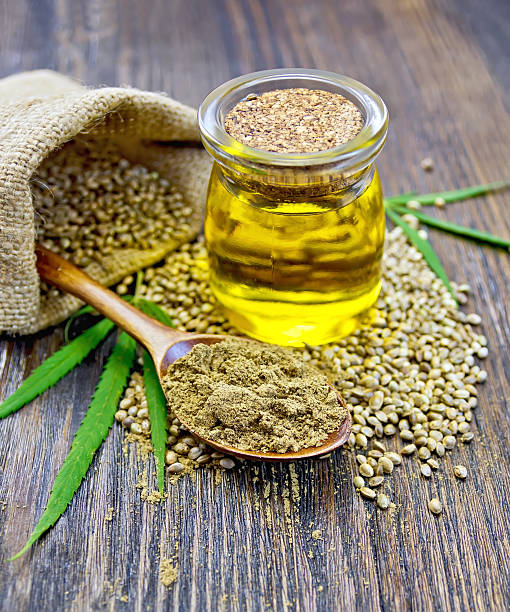 Flour hemp in spoon with oil and bag on board