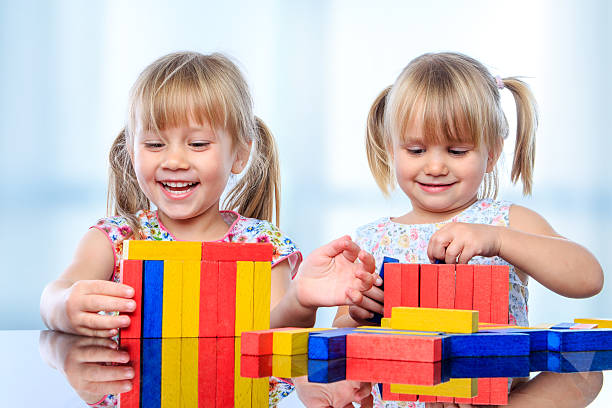istock Two kids building with wooden blocks at table. 498769428