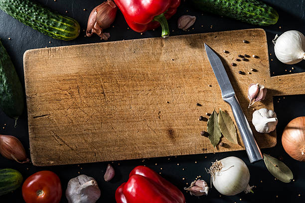 istock Autumn vegetables, spices on old wooden cutting board, stone table 498769988