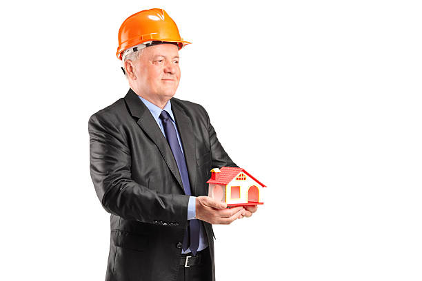 istock Mature architect holding a small model house 498771141