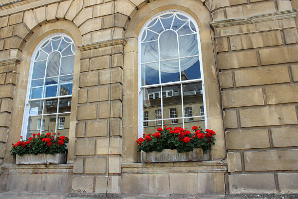 istock Stone window boxes with red flowers (geraniums / pelargoniums), Bathstone house 498771739