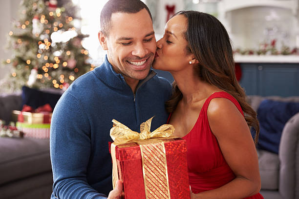 Romantic Couple Exchanging Christmas Gifts At Home