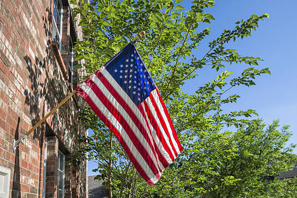 istock American flag in front of a brick home 498786483