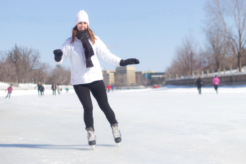 Healthy young woman ice skating during winter