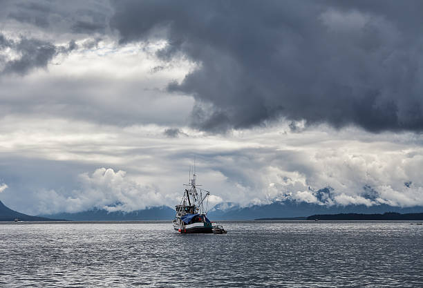 Tempestuosa céu com Barco de Pesca - fotografia de stock