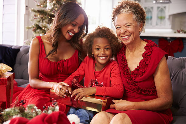 menina com a avó e mãe abrindo presentes de natal - grandmother giving gift child imagens e fotografias de stock