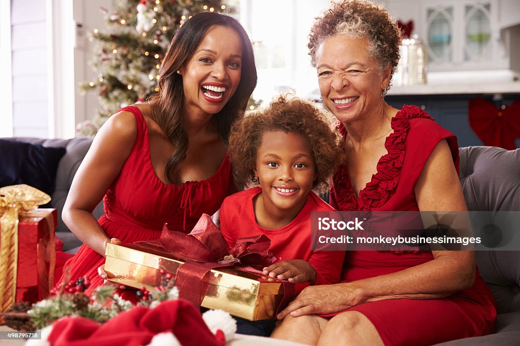Girl With Grandmother And Mother Opening Christmas Gifts Christmas Stock Photo