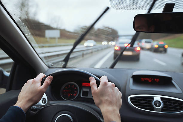 jazda samochodem w deszczowy dzień - driving car traffic men zdjęcia i obrazy z banku zdjęć