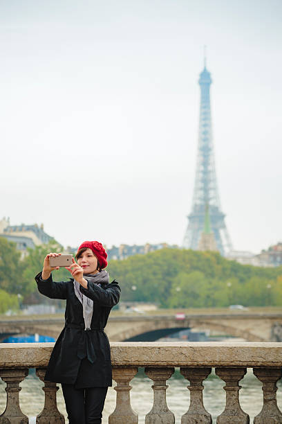 mulher tomando selfie com a torre eiffel em paris. - seine net fotos - fotografias e filmes do acervo