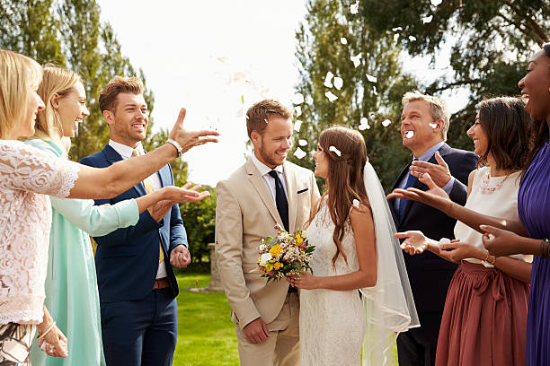 istock Guests Throwing Confetti Over Bride And Groom At Wedding 498798584