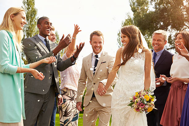 istock Guests Throwing Confetti Over Bride And Groom At Wedding 498798726