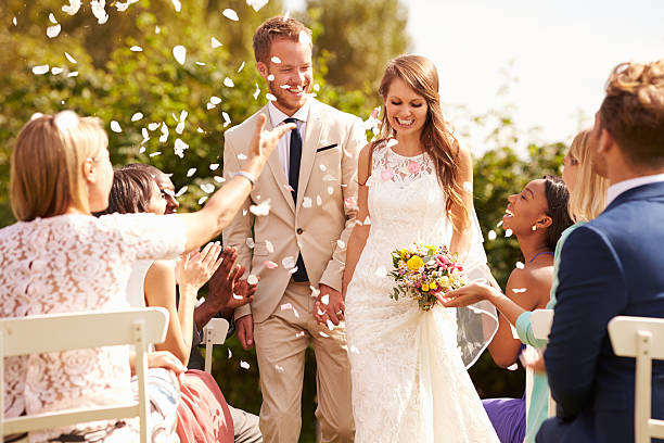 istock Guests Throwing Confetti Over Bride And Groom At Wedding 498799284