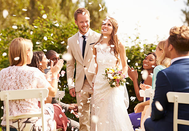istock Guests Throwing Confetti Over Bride And Groom At Wedding 498799400