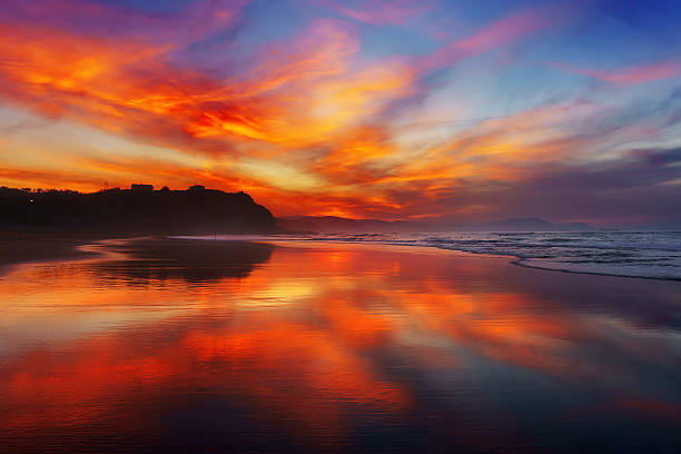 red sunset in Sopelana beach red sunset in Sopelana beach with reflections; sopelana stock pictures, royalty-free photos & images