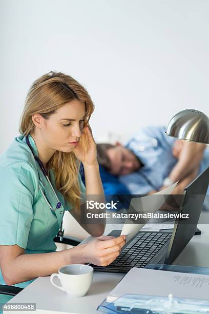 Tired Doctor Doing Paperwork Stock Photo - Download Image Now - 2015, Adult, Business Finance and Industry