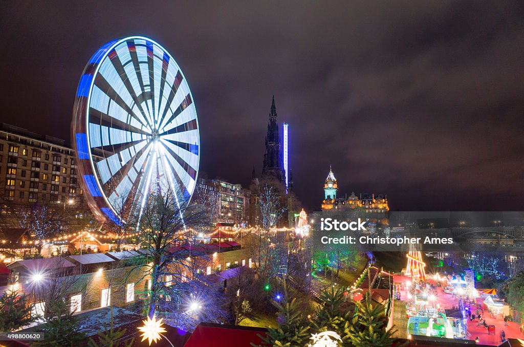 Edinburgh Christmas Festival Amusement Attractions Edinburgh's Princes street, lined with attractions during Edinburgh's Christmas festival. A tall, illuminated ferris wheel is in motion, and there are myriad attractions, lights, and festive shopping on Princes Street Gardens. Edinburgh - Scotland Stock Photo