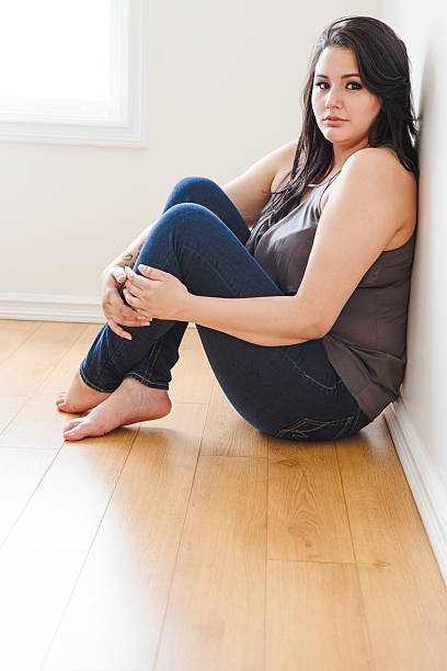 istock Beautiful young woman sitting on hardwood floor 498802430