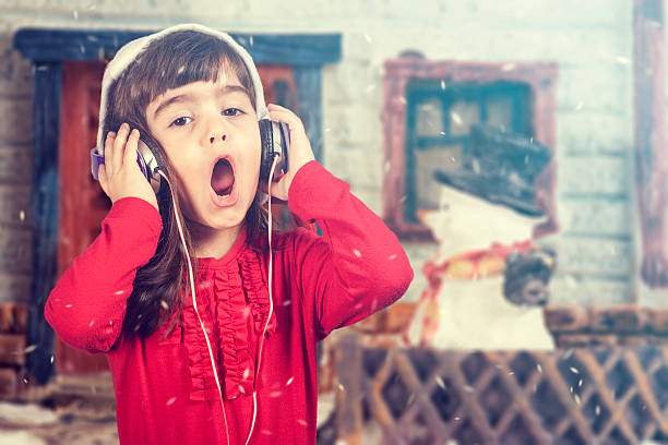 adorável santa menina ouvindo música e cantando natal carols - santa claus audio - fotografias e filmes do acervo