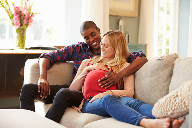 istock Pregnant Couple At Home Relaxing On Sofa Together 498805066