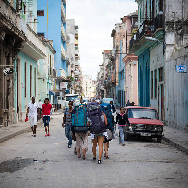 Havana, Cuba - December 17, 2014: Four young women backpacking in Cuba walk down a street in Centro Habana in Havana.