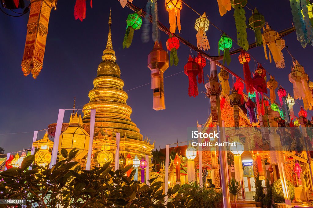 Gold pagoda and lantern hung up on the rail Gold pagoda and lantern hung up on the rail to the prosperity in loy kratong festival at wat phra that haripunchai lamphun Thailand at night time Thailand Stock Photo