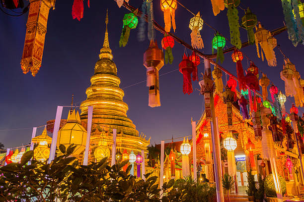 Gold pagoda and lantern hung up on the rail Gold pagoda and lantern hung up on the rail to the prosperity in loy kratong festival at wat phra that haripunchai lamphun Thailand at night time chiang mai province stock pictures, royalty-free photos & images