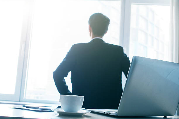 istock Businessman looking through window in office 498806060