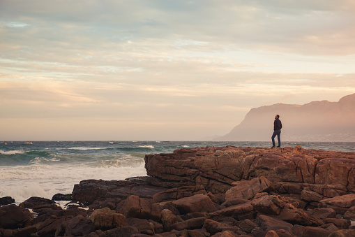 Man enjoying view of wavy ocean during sunset (South Africa)