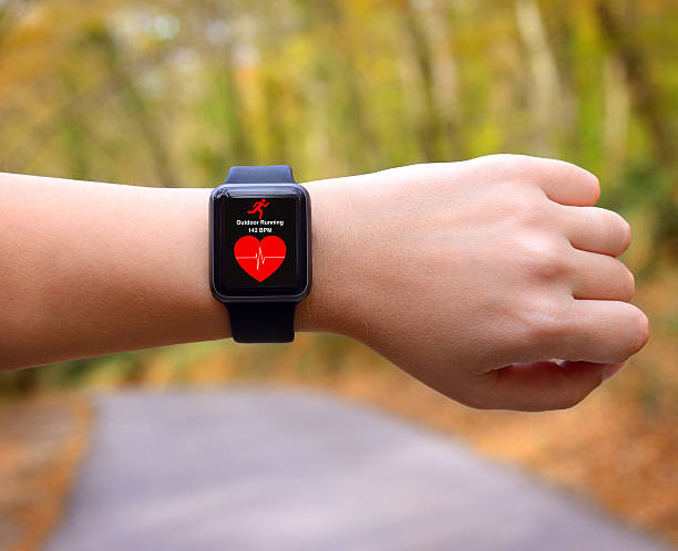 Wearable technology smart watch Runner using smart watch with heart rate application on a running track. cardiac conduction system stock pictures, royalty-free photos & images