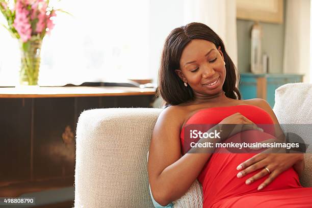 Pregnant Woman Relaxing On Sofa At Home Stock Photo - Download Image Now - African-American Ethnicity, Pregnant, Women