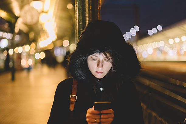 istock Woman at the railway station texting on smartphone 498809308