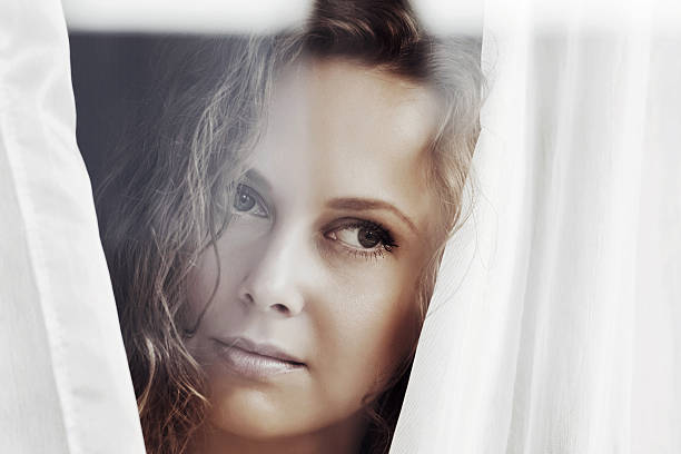 istock Sad beautiful woman looking out the window 498815941