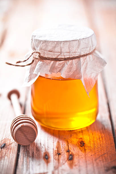 istock full honey pot and honey stick 498829483