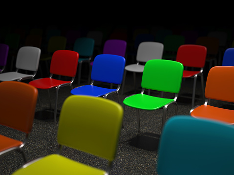 Many illuminated colorful chairs standing in a grid symbol for individuality and diversity