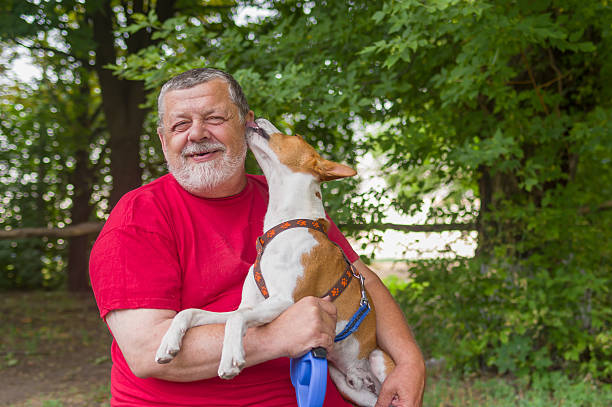 istock Senior man is happy when his pet shows affection 498830262