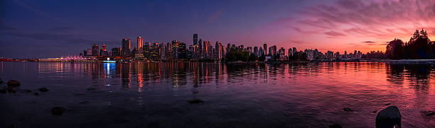 Beautiful Vancouver skyline and harbor with idyllic sunset glow, Canada Panoramic view of impressive Vancouver skyline and harbor with beautiful red sunset glow, British Columbia, Canada vancouver at night stock pictures, royalty-free photos & images