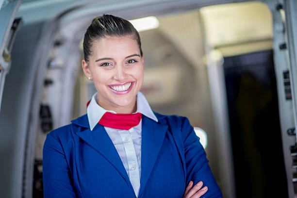 Happy flight attendant Happy flight attendant at the door of an airplane crew stock pictures, royalty-free photos & images