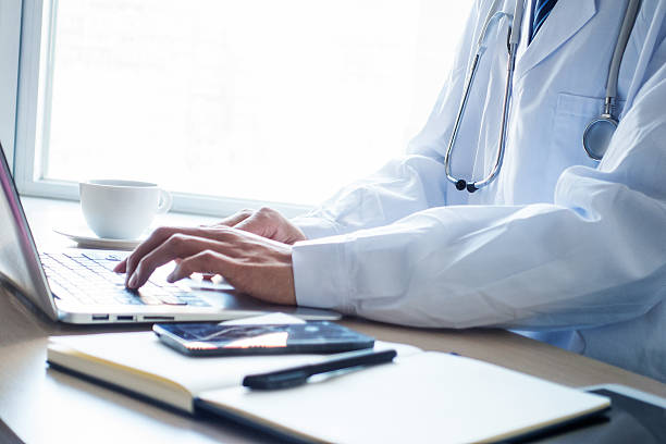 istock Doctor typing information on the computer in office 498832950
