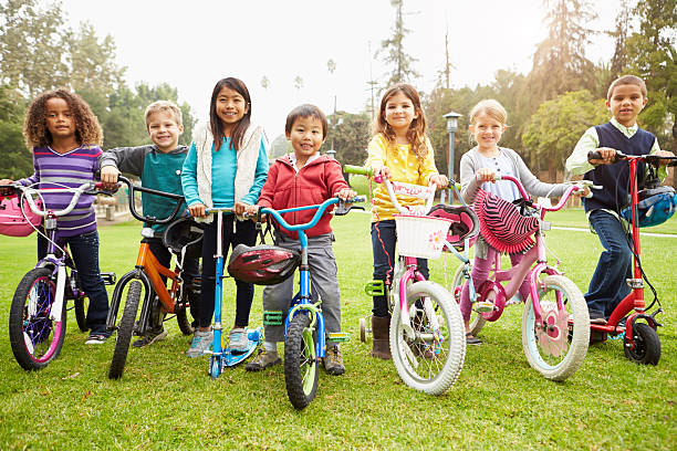 istock Young Children With Bikes And Scooters In Park 498834015