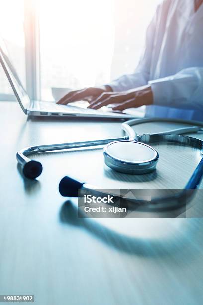 Doctor Typing Information On The Computer In Office Stock Photo - Download Image Now