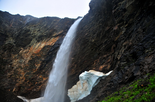 Waterfall and snowfield. Norwegian landscape.