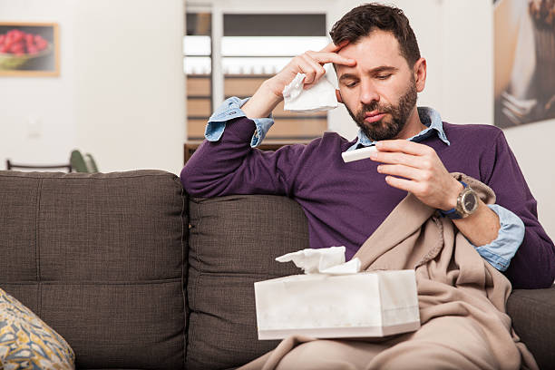 istock Guy with a cold and fever at home 498839938