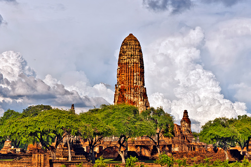 Southwest view of Wat Phra Ram temple complex in Ayutthaya historical park in Thailand, with the Prang tower in the middle, the before thunderstorm cloudscape is at background